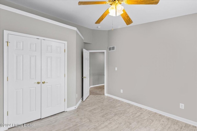 unfurnished bedroom featuring light wood finished floors, a closet, visible vents, a ceiling fan, and baseboards