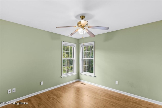 unfurnished room with visible vents, ceiling fan, baseboards, and wood finished floors