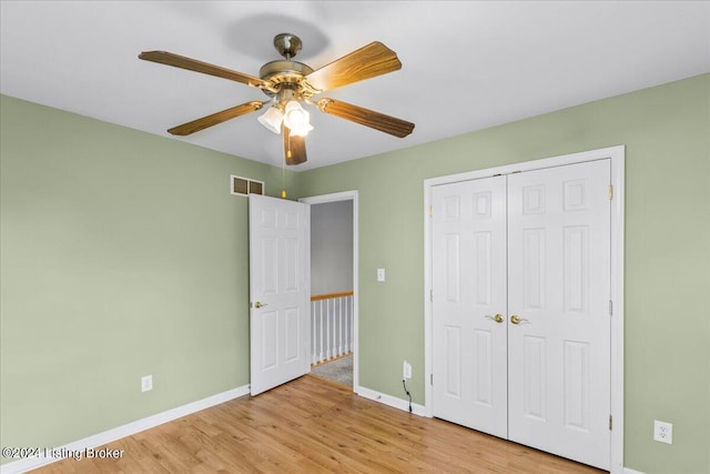 unfurnished bedroom featuring visible vents, baseboards, light wood-style flooring, ceiling fan, and a closet