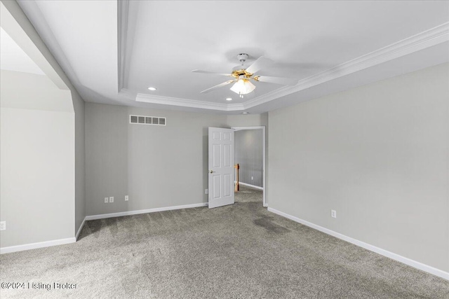 empty room featuring baseboards, visible vents, ceiling fan, and a tray ceiling