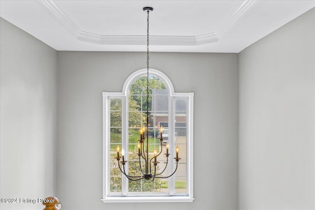 details with a chandelier, a raised ceiling, and crown molding