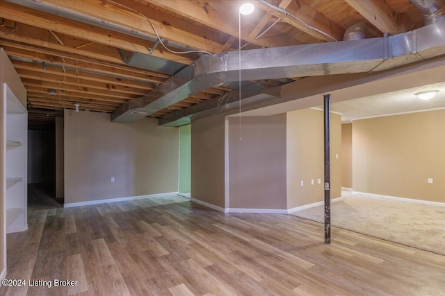 finished basement featuring wood finished floors and baseboards