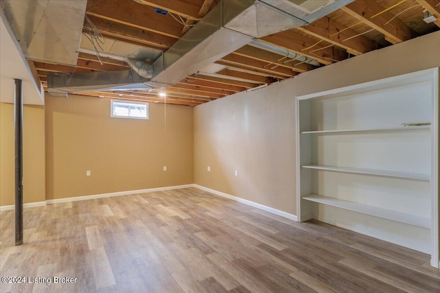 below grade area featuring baseboards and wood finished floors