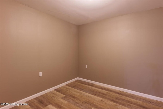 empty room featuring wood finished floors and baseboards