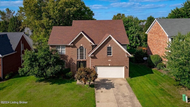 traditional-style home featuring a garage, a front lawn, concrete driveway, and brick siding