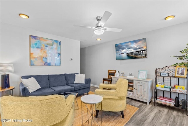 living area featuring light wood-type flooring, ceiling fan, and baseboards