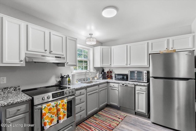 kitchen with stainless steel appliances, a sink, white cabinetry, and under cabinet range hood