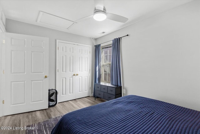 bedroom featuring a closet, visible vents, attic access, a ceiling fan, and light wood-type flooring