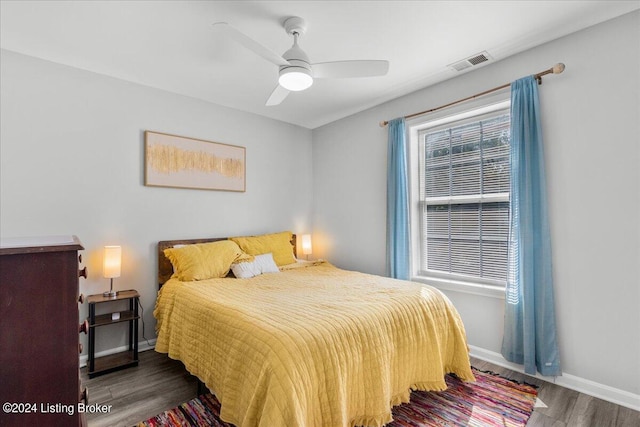 bedroom with baseboards, multiple windows, visible vents, and dark wood-style flooring