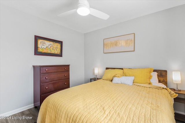 bedroom with a ceiling fan, baseboards, and wood finished floors