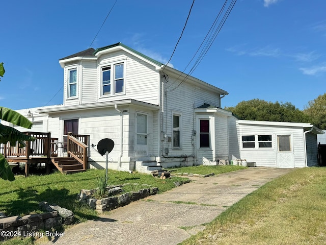 rear view of house with a lawn and a deck