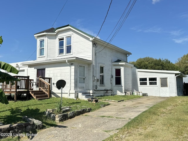 view of front facade with entry steps, a deck, and a front yard