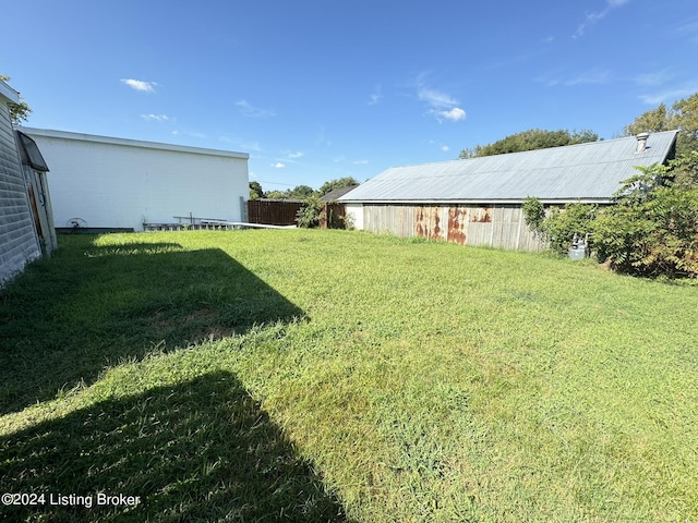 view of yard featuring an outbuilding and fence