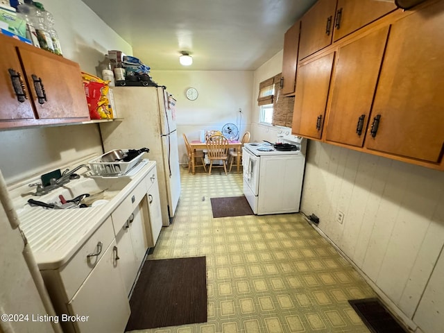 kitchen with white range with electric stovetop, sink, and light tile patterned flooring