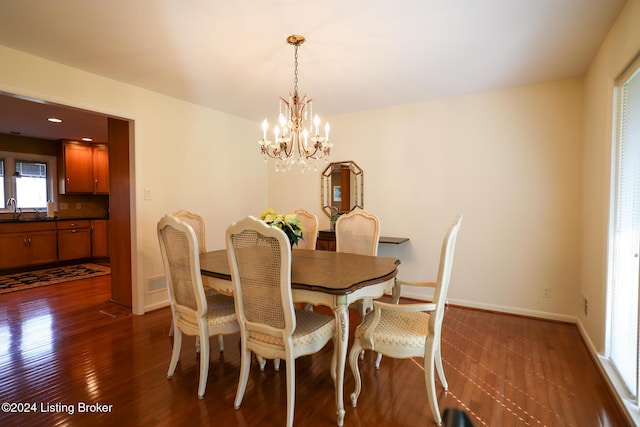 dining space featuring a notable chandelier, dark hardwood / wood-style floors, and sink