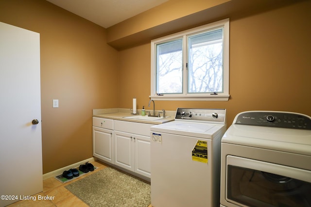 washroom with washer and clothes dryer, light tile patterned floors, cabinets, and sink