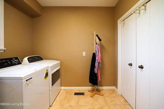 laundry area featuring washing machine and dryer and light tile patterned floors