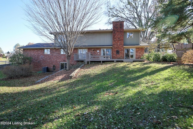 rear view of house featuring a lawn and a deck