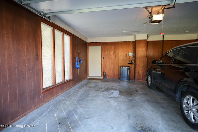 garage with wood walls and a garage door opener