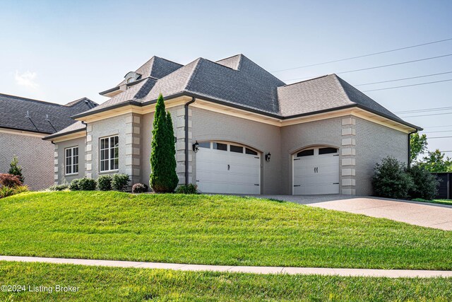 view of front of house featuring a front lawn and a garage