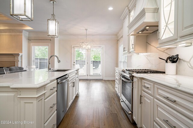 kitchen with stainless steel appliances, sink, dark hardwood / wood-style floors, decorative backsplash, and a kitchen island with sink