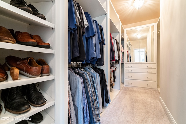 walk in closet featuring light colored carpet