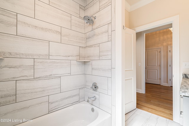 bathroom featuring hardwood / wood-style floors, tiled shower / bath combo, and crown molding