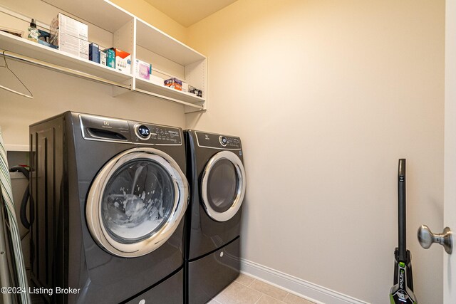 laundry room featuring washing machine and clothes dryer and light tile patterned flooring