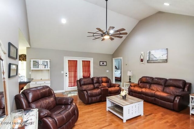 living room with hardwood / wood-style floors, high vaulted ceiling, french doors, and ceiling fan