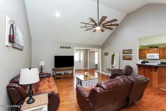 living room with ceiling fan, high vaulted ceiling, and light hardwood / wood-style floors