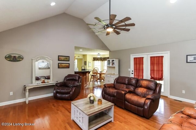 living room with ceiling fan, high vaulted ceiling, and hardwood / wood-style floors