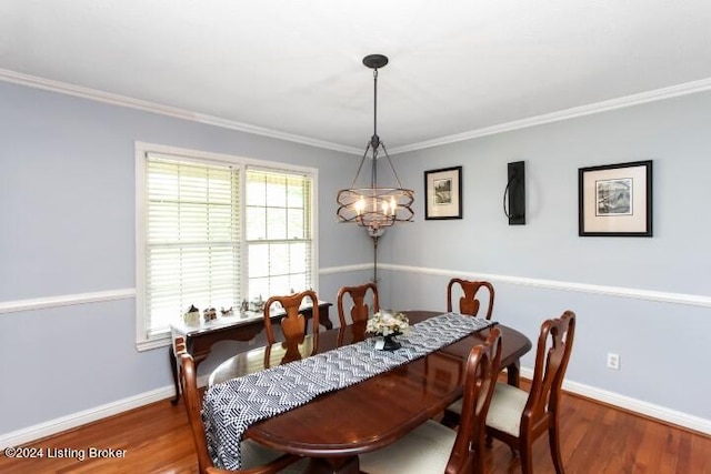 dining area with crown molding, dark hardwood / wood-style flooring, and an inviting chandelier