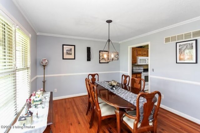 dining area with a notable chandelier, crown molding, and dark hardwood / wood-style flooring