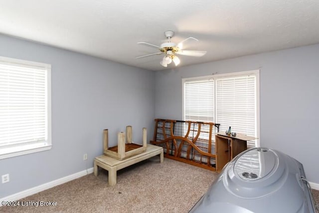 carpeted bedroom featuring ceiling fan and multiple windows