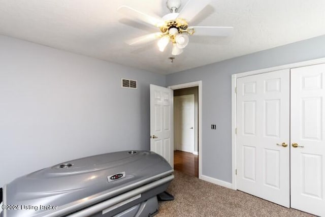 interior space with ceiling fan, a closet, and light carpet