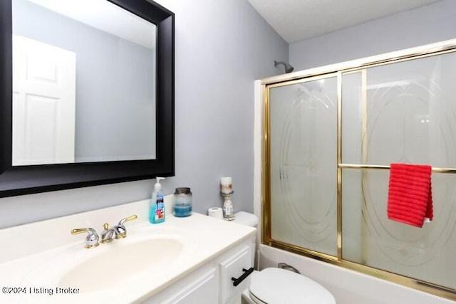 full bathroom with toilet, bath / shower combo with glass door, and vanity