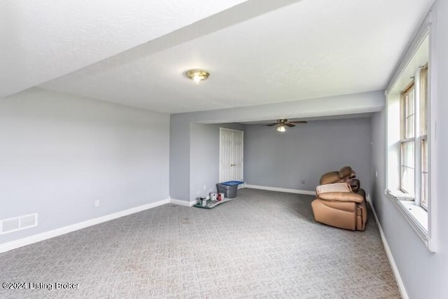 interior space with carpet floors, ceiling fan, and a textured ceiling