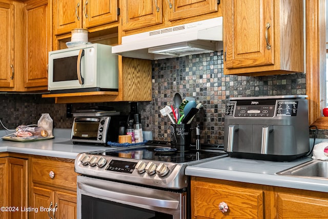 kitchen with tasteful backsplash and electric range