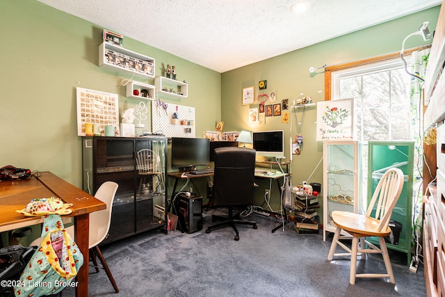 carpeted home office featuring a textured ceiling