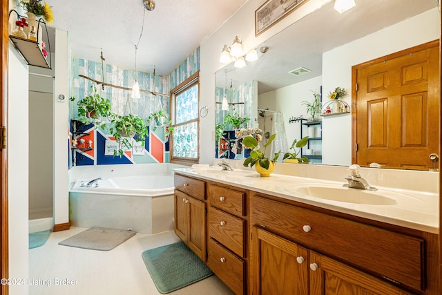 bathroom with vanity, a textured ceiling, and independent shower and bath