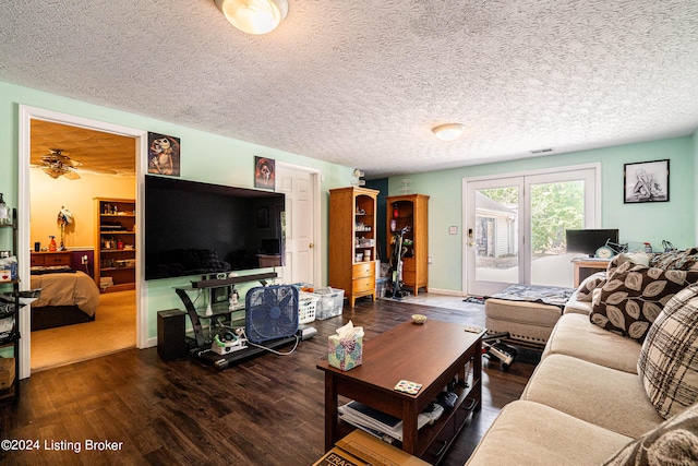 living room featuring hardwood / wood-style floors, ceiling fan, and a textured ceiling