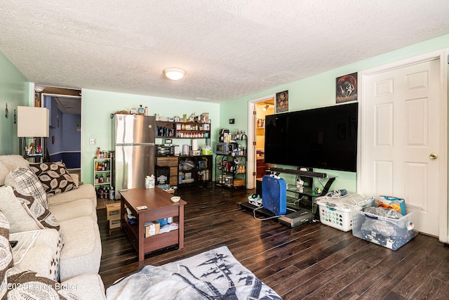 living room with a textured ceiling and dark hardwood / wood-style floors