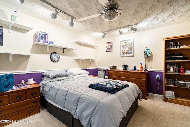 bedroom featuring rail lighting, ceiling fan, and light carpet