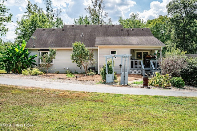 rear view of house featuring a yard