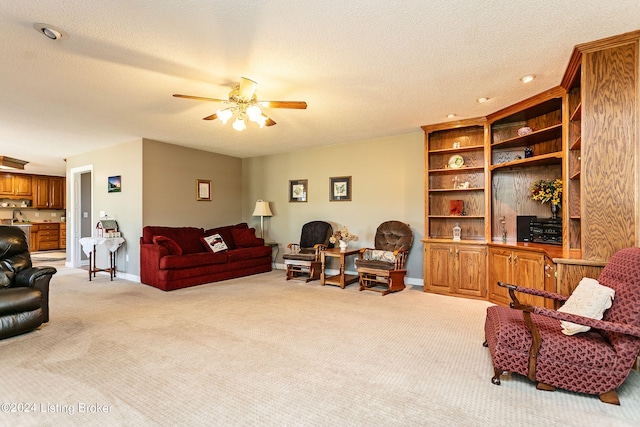 carpeted living room with ceiling fan and a textured ceiling