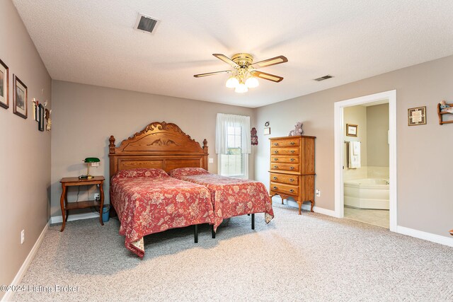 carpeted bedroom with a textured ceiling, ceiling fan, and ensuite bath