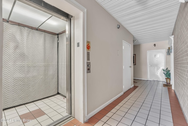 corridor with elevator and light tile patterned floors