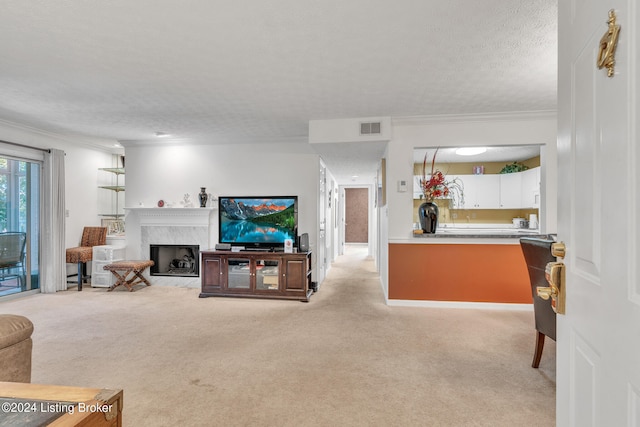 carpeted living room with a textured ceiling, a premium fireplace, and ornamental molding