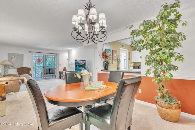 dining space with a textured ceiling, ornamental molding, light carpet, and a notable chandelier