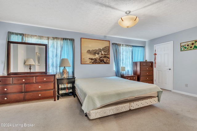 bedroom featuring a textured ceiling and light colored carpet